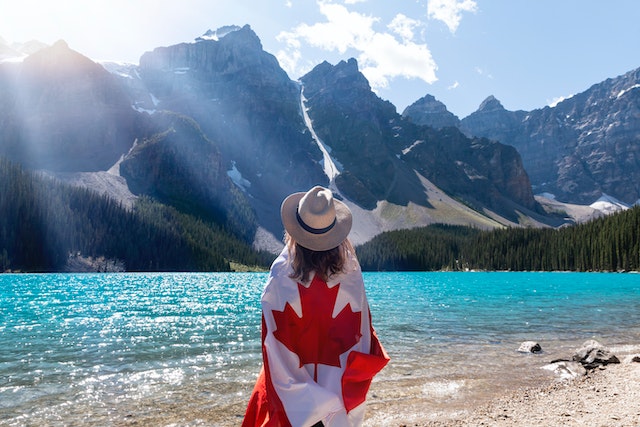 Woman wearing Canada flag looking at mountains